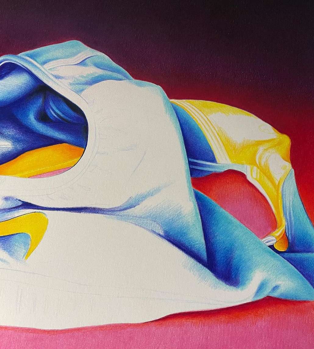Still life pencil art of a white and light blue t-shirt with yellow accents, and a pink and red background blend.