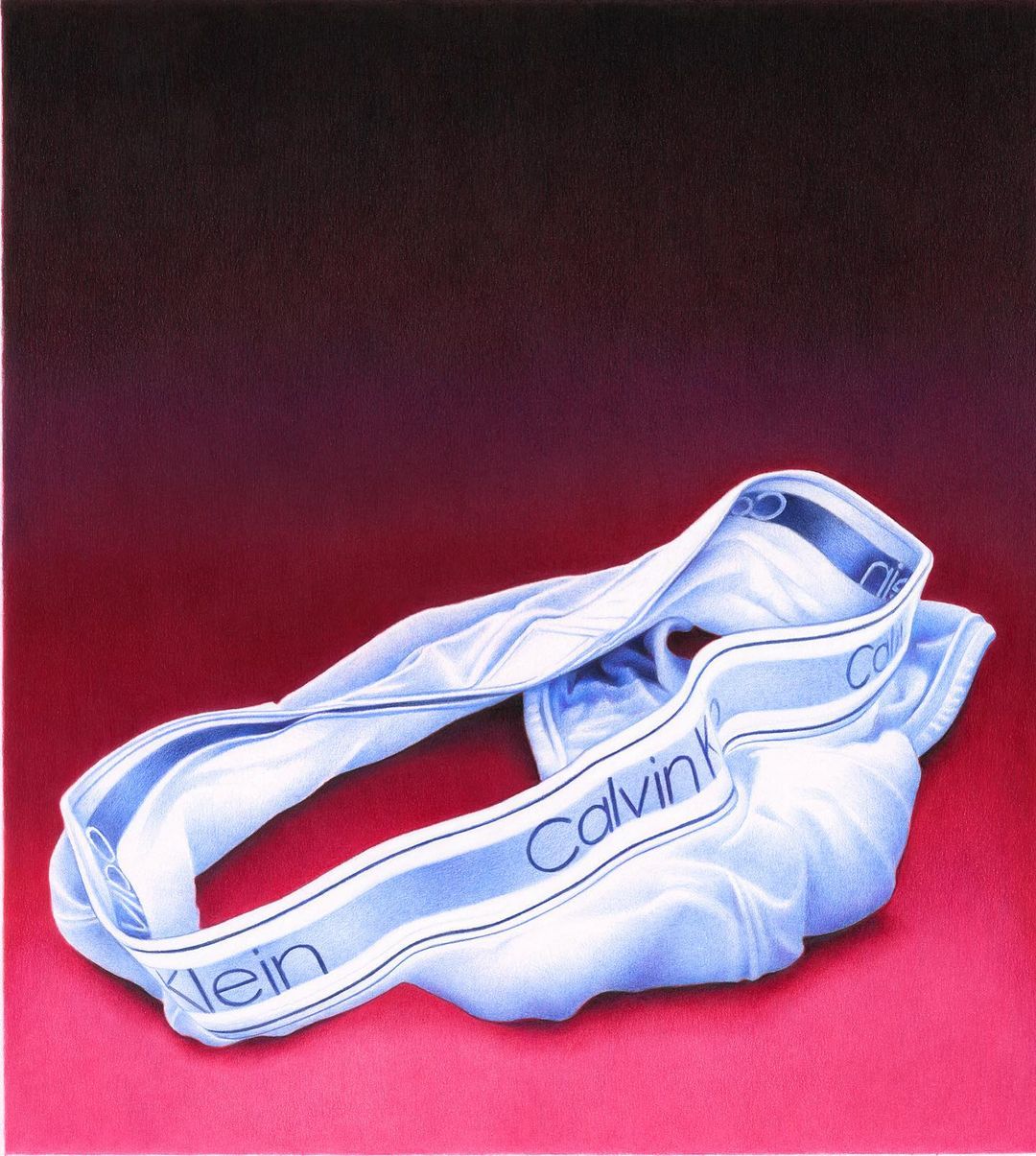Artful studio shot of white Calvin Klein underwear resting against a gradient red background, highlighting the brand logo.