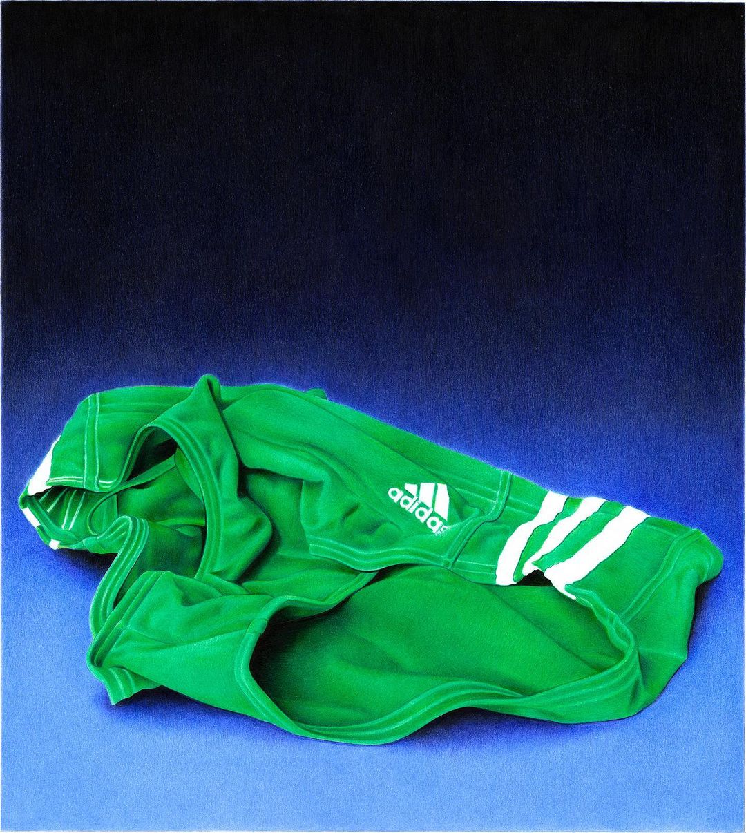Close-up of a green Adidas sports shirt with white stripes and logo on a table with dark-to-light blue background. 