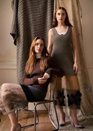 Two women pose indoors wearing knit dresses and skirts, one seated on a chair, neutral tones with a vintage and fashion editorial style.