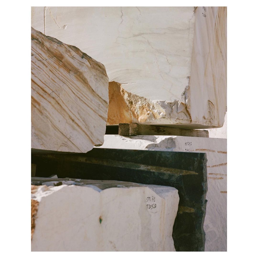 Stacked marble blocks showcasing unique patterns and textures in natural light, ideal for architecture or design-related projects.