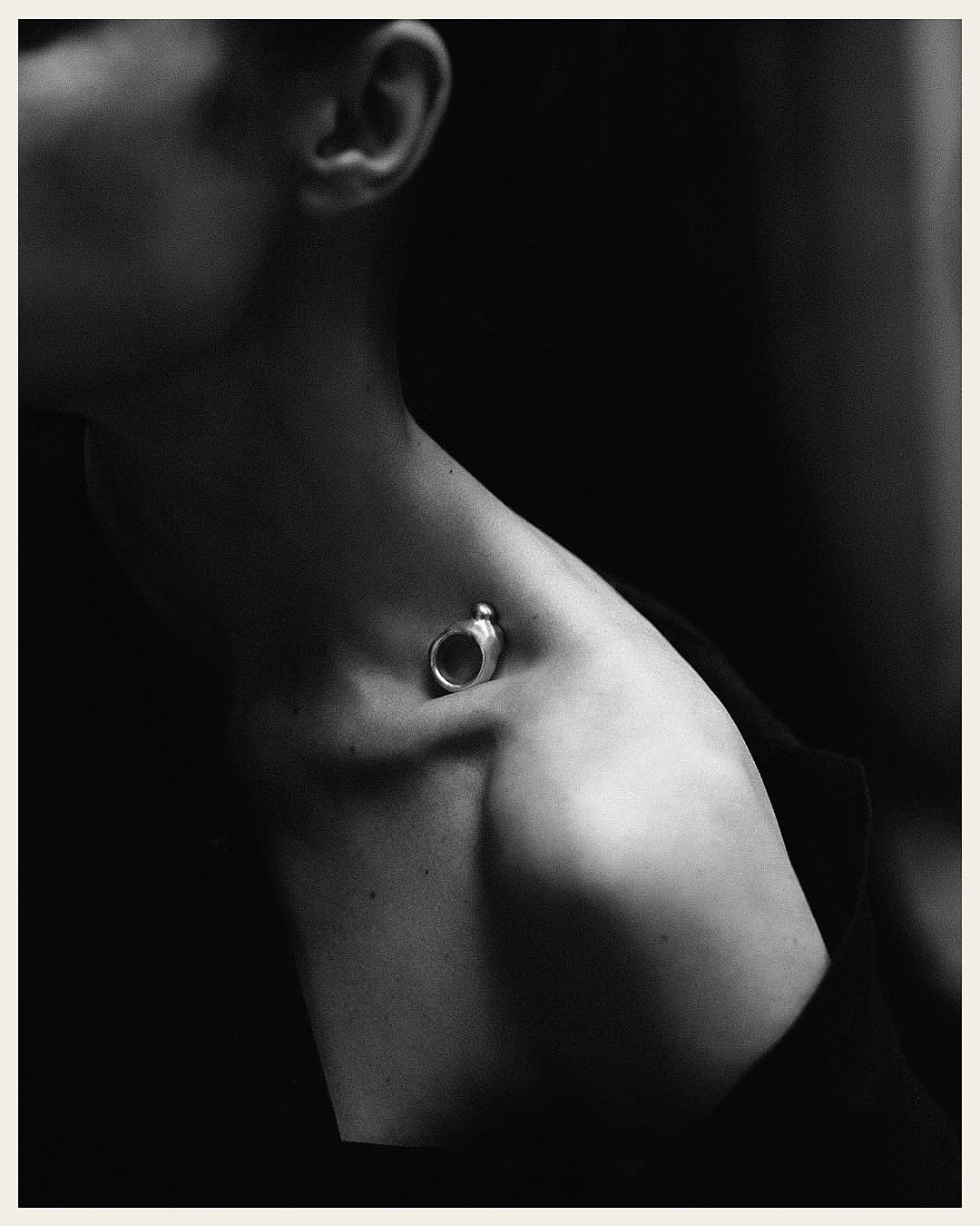 Close-up monochrome portrait of a woman wearing a silver ring resting in her collarbone by Rich Stapleton
