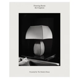Black and white photograph of a table lamp on a dark side table by photographer Rich Stapleton