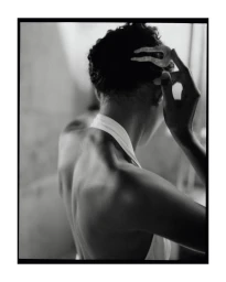 Monochrome portrait from behind of a person adjusting a decorative hair clip