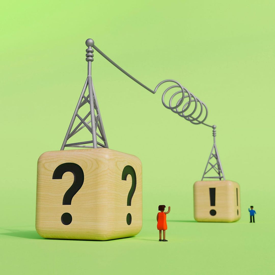 Conceptual image of two communication towers, represented by miniature figurines, wooden blocks with a question and exclamation mark.