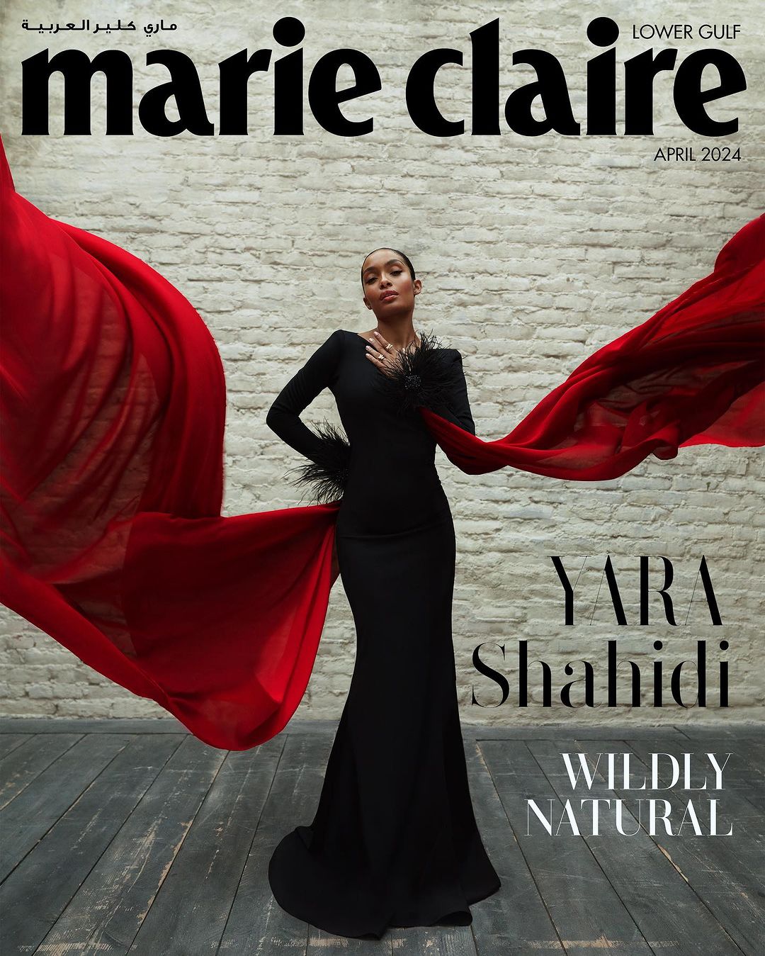 Yara Shahidi graces the Marie Claire Lower Gulf cover, April 2024, in a black gown with red flowing fabric and feathered details.