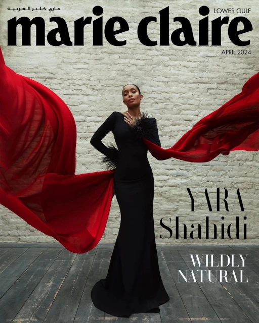 Yara Shahidi graces the Marie Claire Lower Gulf cover, April 2024, in a black gown with red flowing fabric and feathered details.