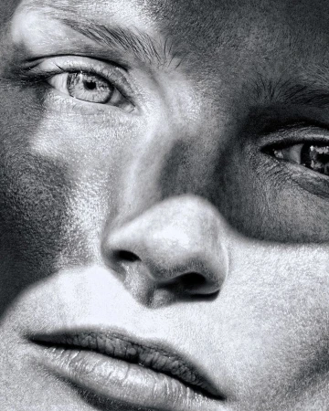 Extreme close-up portrait of a woman face with high contrast monochrome grain texture captured by photographer Rayan Ayash.