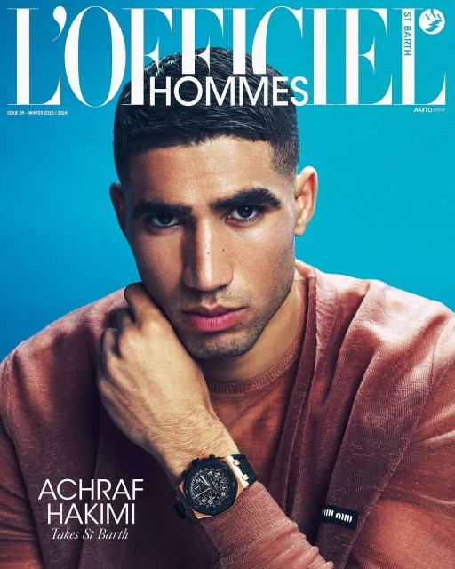Magazine cover featuring Achraf Hakimi in a close-up shot wearing a mauve shirt and a wristwatch against a blue background.