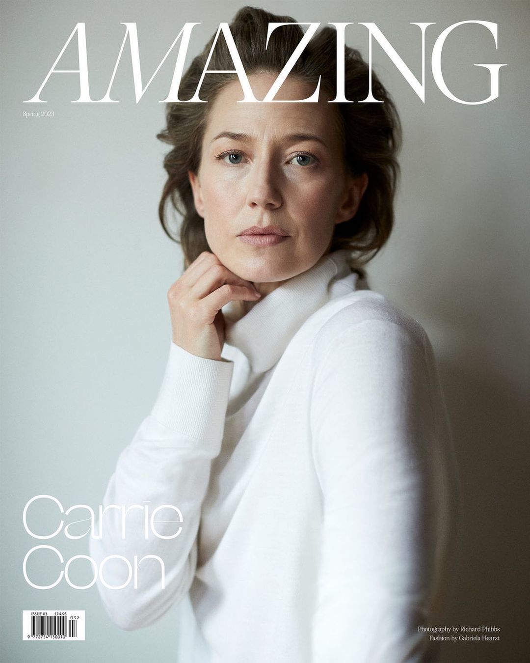 Magazine cover featuring a woman in a white turtleneck sweater with a neutral expression, set against a light gray background.
