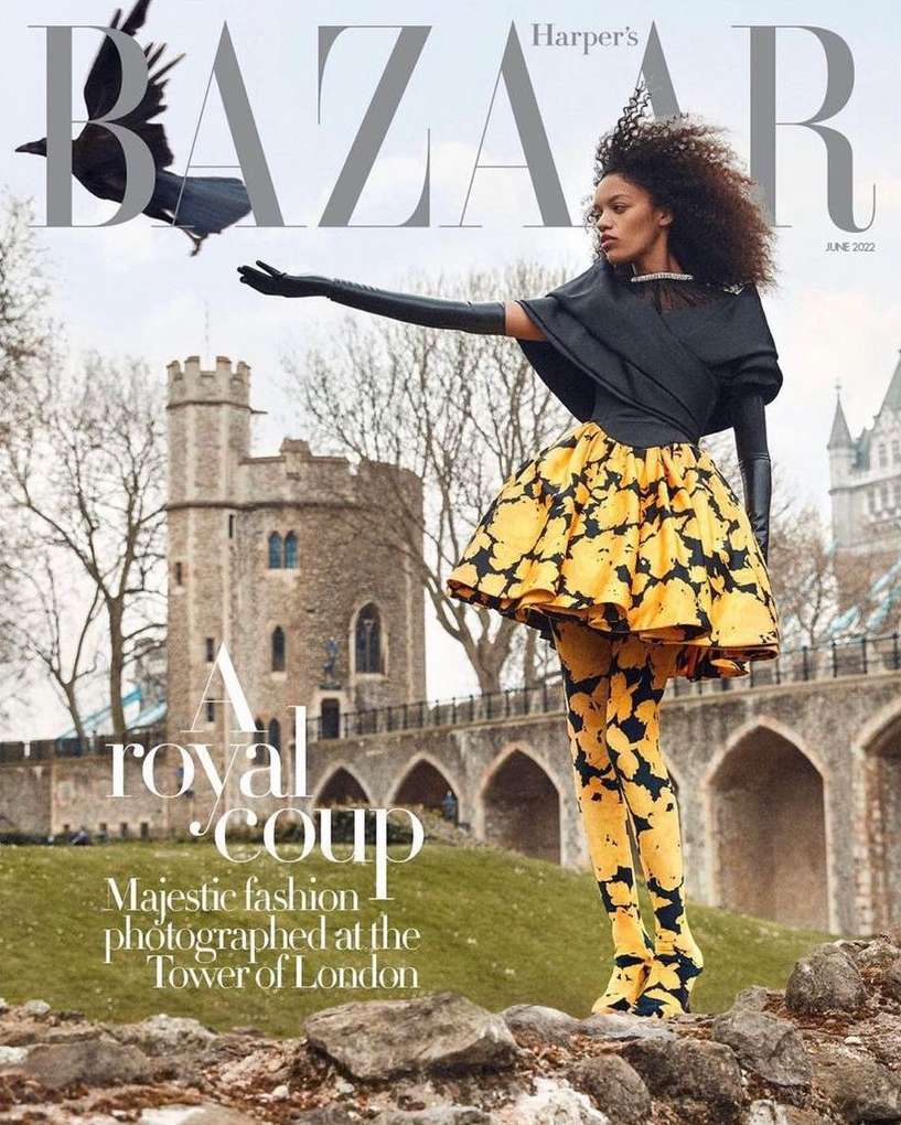 Fashion editorial featuring a Black model in a black and yellow dress, with the Tower of London and a raven in the background.
