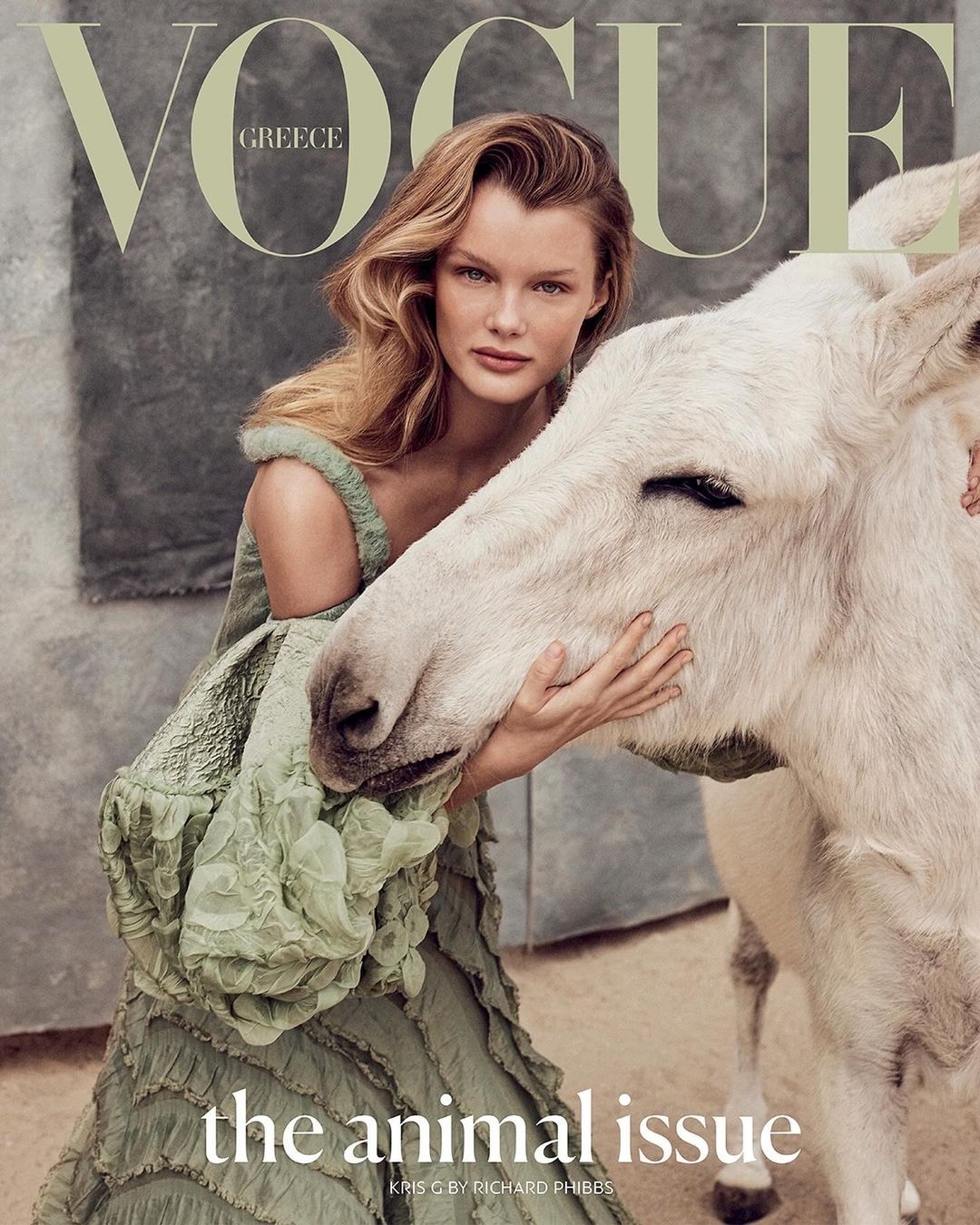Vogue Greece cover featuring a woman in a green dress embracing a white donkey, set against a neutral backdrop with visible text.