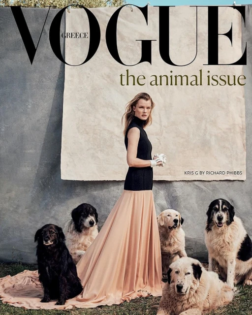 Vogue Greece cover featuring a fashion model in black top and long skirt, surrounded by a group of large breed dogs on grass.
