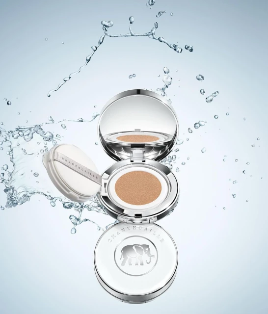 Chantecaille compacts floating in a blue and white space surrounded by water droplets in a beauty and product shot, luxury.