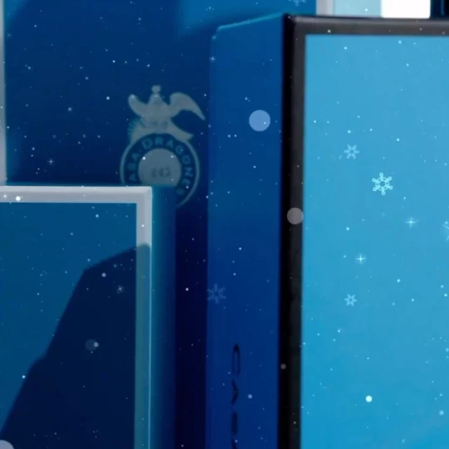 Elegant blue product packaging with a logo and snowflakes, illuminated with a soft light, create a festive mood in a close-up view.