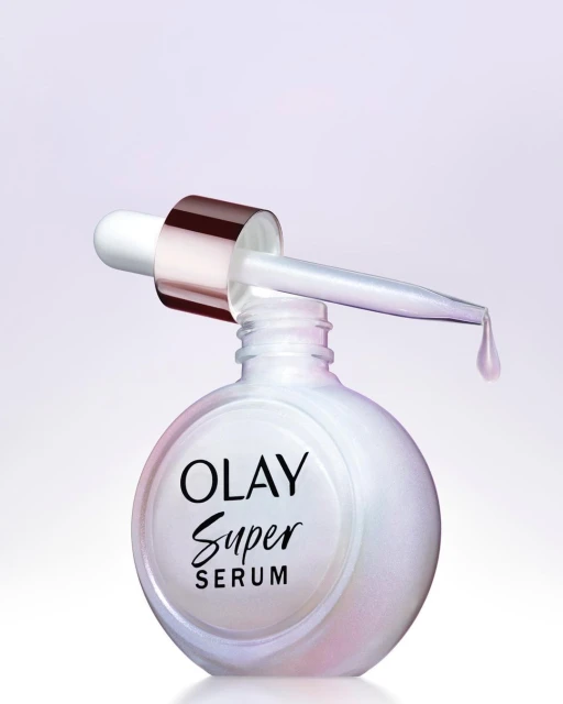 Close-up studio shot of Olay Super Serum bottle with dropper. Product focus with cosmetic and beauty industry theme, featuring white bottle.