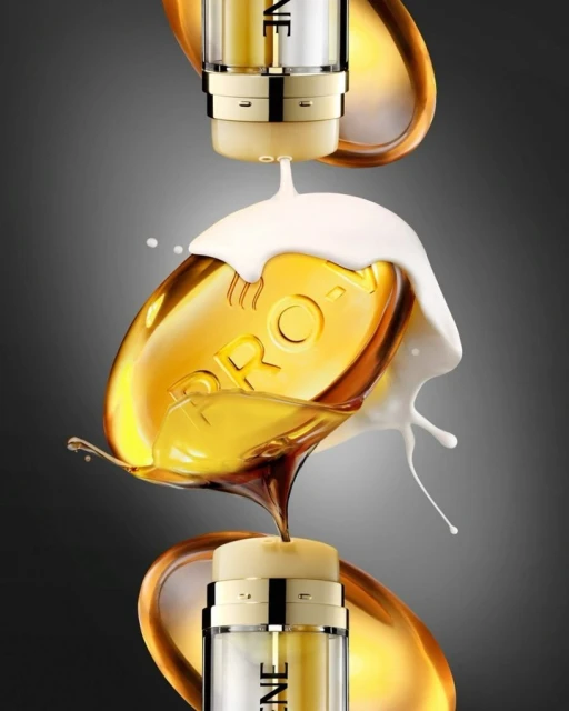 Close-up studio shot of hair product bottles dispensing fluid, featuring gold accents, creating splash effects against a grey backdrop.