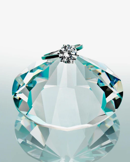 Close-up studio shot of a round-cut diamond solitaire engagement ring on a faceted glass diamond figure against a gradient white background.