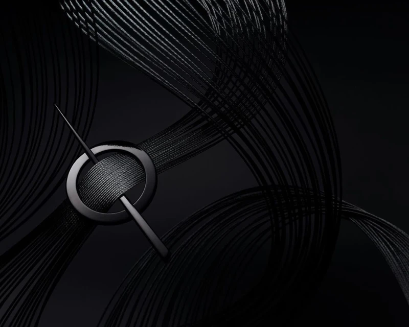 Abstract, high-angle studio shot: Black metal pin intersecting a circular ring resting on a surface with curved black strings.