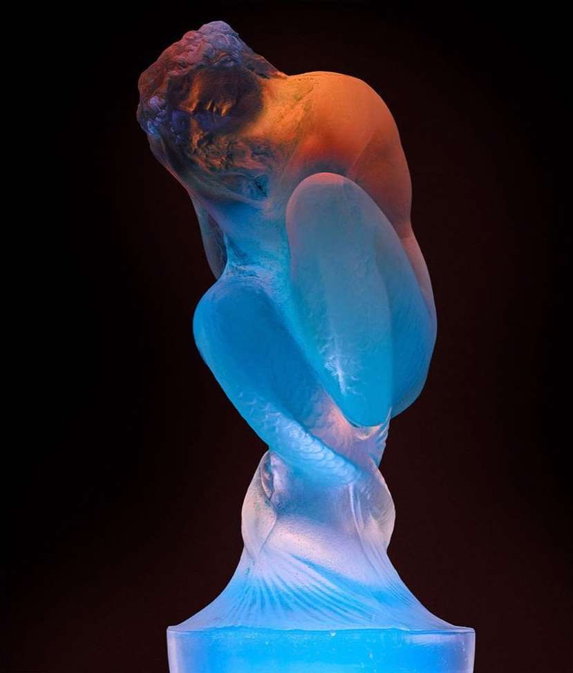 Female figure art sculpture with blue and orange lighting on dark background. Artistic rendering of a woman’s body.