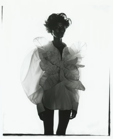 Black and white portrait of a model in a white shirt with sculptural leaf appliques by photographer Rid Burman