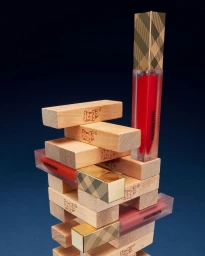 A stack of wooden Jenga blocks interspersed with branded cosmetic tubes against a deep blue background.