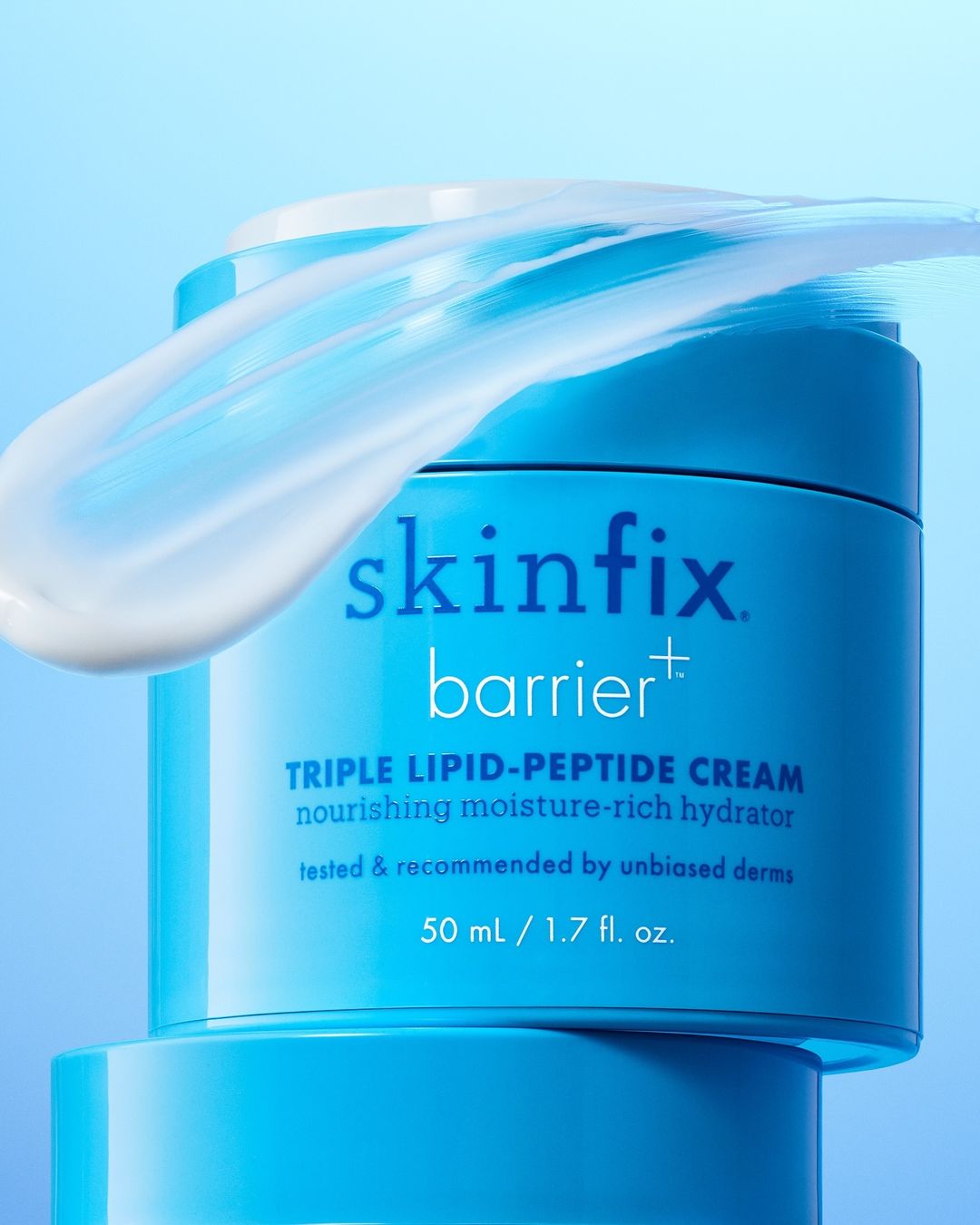 Cosmetic product shot of Skinfix Barrier+ Triple Lipid-Peptide Cream in a blue jar with white cream on top against a gradient blue background.