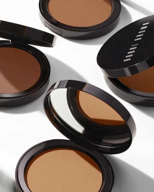 Cosmetic bronzer compacts displayed in an arrangement, showcasing the makeup product's brown shades and compact design.
