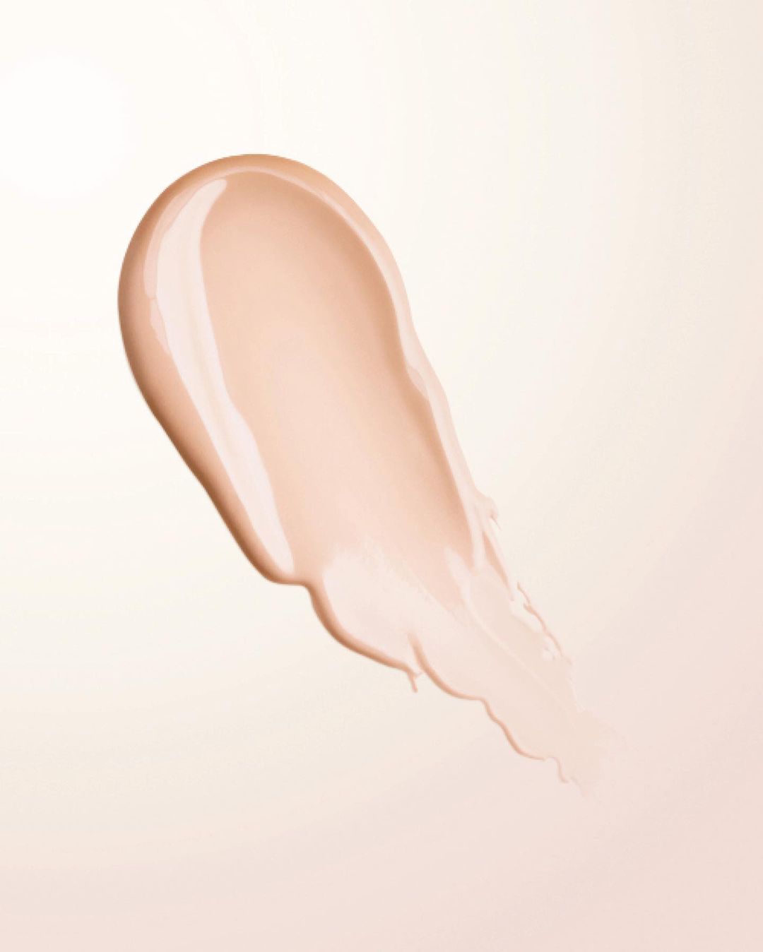 Close-up of a swatch of beige makeup foundation. Creamy, smooth cosmetic product shot on a soft, neutral background.