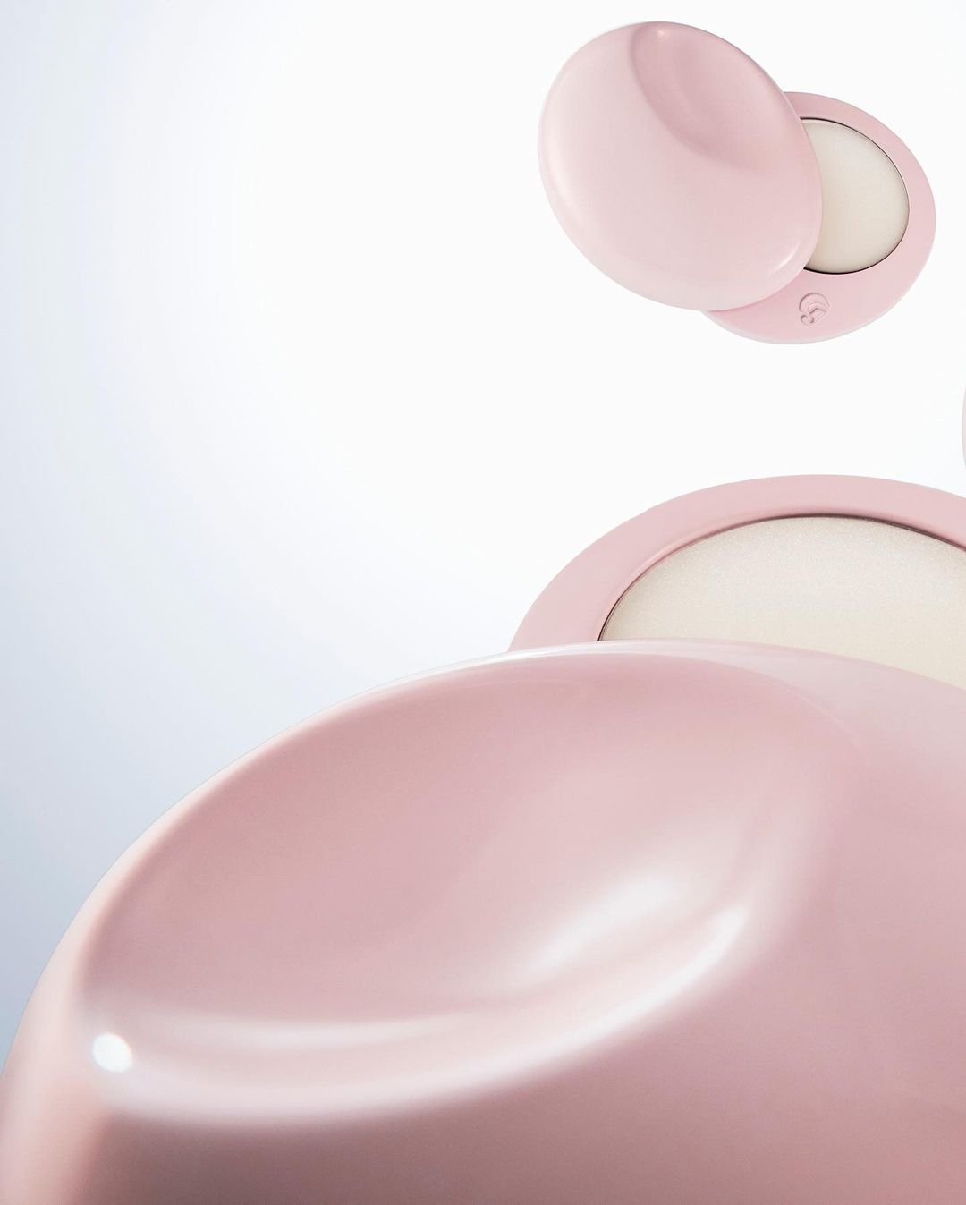 Close-up of pink compact powder cases on a white background. Beauty product and make-up for cosmetics advertising.