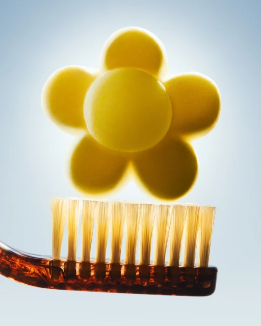 Toothbrush with a yellow molecular structure above it, creating a clean and bright visual for oral hygiene and dental health.