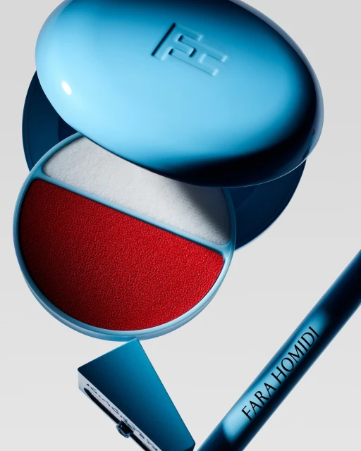 Close-up product shot of a light blue compact with red and white powder, along with a blue handled razor and makeup pencil.