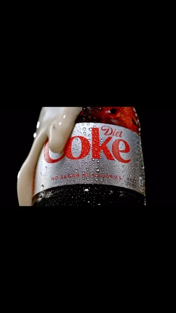 Close-up of a Diet Coke bottle with condensation and foam. The iconic logo and silver can are prominently featured against a black background.