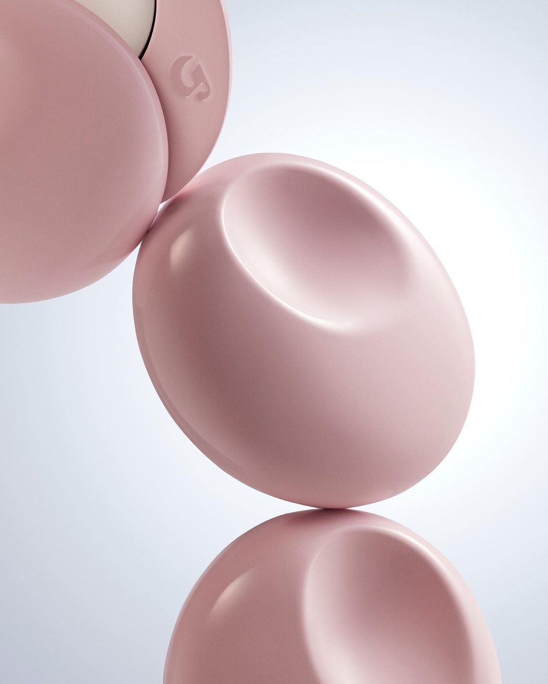 Abstract studio shot of three smooth, pink, oval cosmetic containers stacked against a bright white gradient background with reflection.