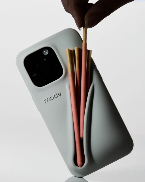 Grey cellphone case with the word 'rhode' and multiple candy sticks in a light studio setting. Modern, clean design is highlighted.