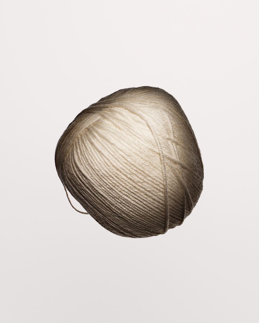 Close-up photo of a single ball of yarn in a soft neutral color, perfect for knitting or crochet projects with a smooth texture.