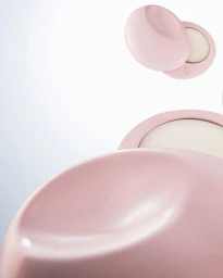 Pink glossy cosmetic compacts floating against a clean white gradient background
