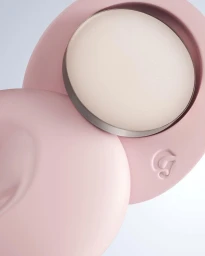 Close-up product photography of a round pink makeup compact with a creamy white highlighter by Rikky Fernandes