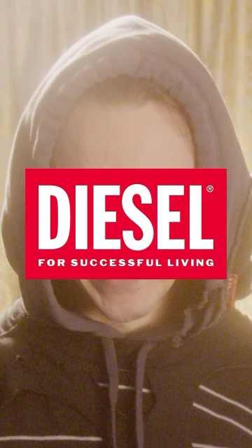 Portrait of a person in a hoodie partially obscured by a red Diesel logo; the individual is backlit with warm tones.