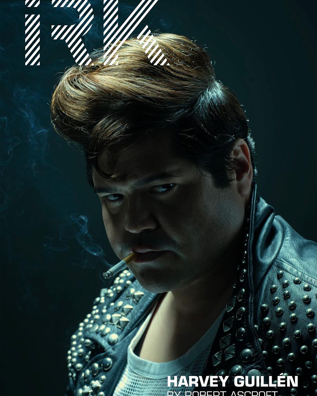 Man with a pompadour hairstyle wearing a studded leather jacket and smoking a cigarette in a portrait by Robert Ascroft.