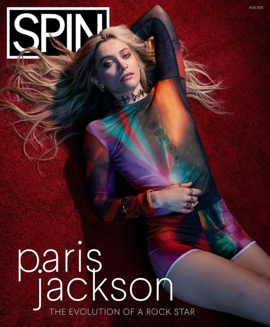 Paris Jackson poses on a red textured surface, wearing a patterned top and shorts, on the cover of Spin magazine, August 2022 issue.