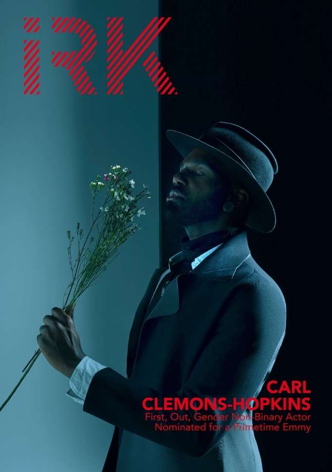 Magazine cover featuring a Black non-binary actor holding flowers, wearing a dark coat and hat, against a teal and black background.