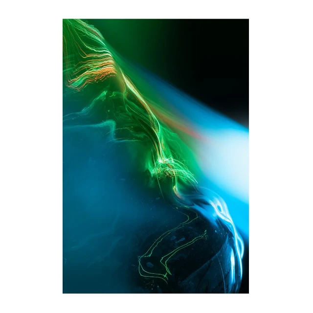 Abstract long exposure photography with swirling lines of light in shades of green, blue, and orange against a dark background.
