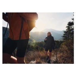 Two hikers walking along a sunny mountain trail, captured by Robert Elmengard in Munich