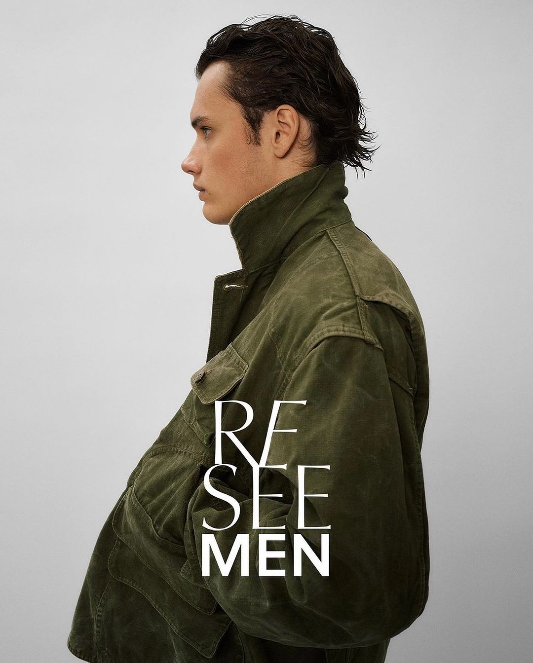 Profile shot of a young adult male in an olive-green corduroy jacket against a neutral backdrop, featuring the text 'RE SEE MEN'.