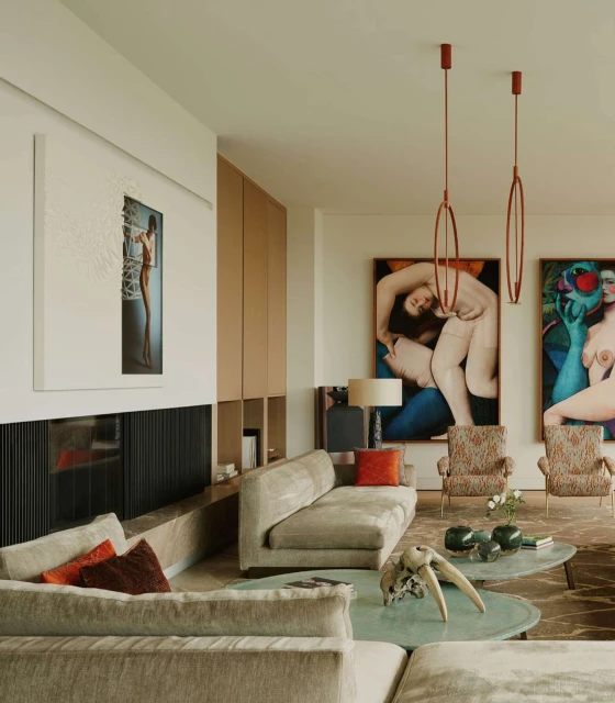 Living room interior with grey sofas, contemporary art, and patterned armchairs in a light-filled space, complemented by modern lighting.