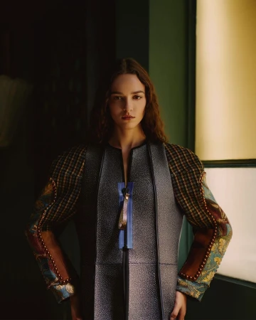 Portrait of a female model wearing a structured patterned jacket with blue zipper detail photographed by Robert Rieger