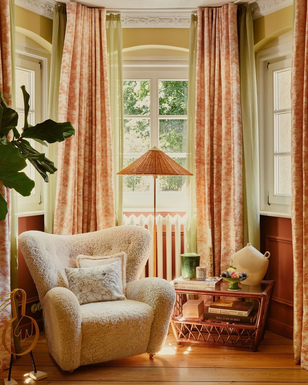 Comfortable armchair in a cozy living room with warm lighting and decorative accents, including curtains, a lamp, and a side table.