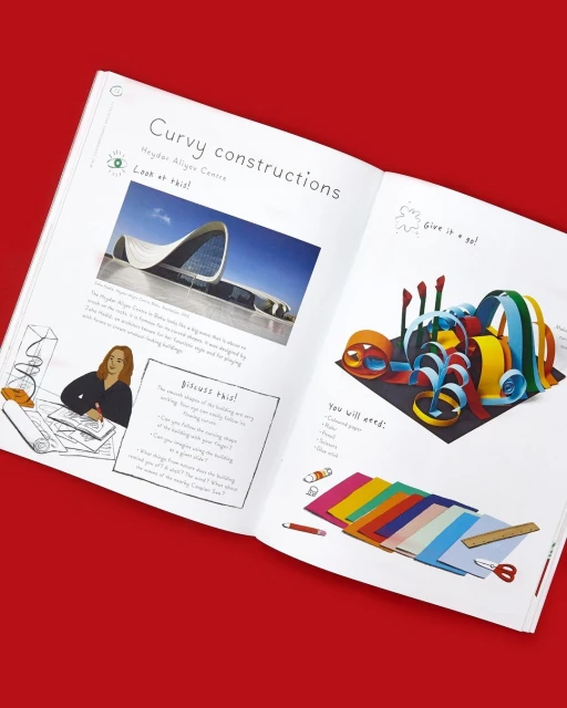Open book spread features colorful paper art craft project instructions, studio photography, vibrant colors on white paper, red backdrop.
