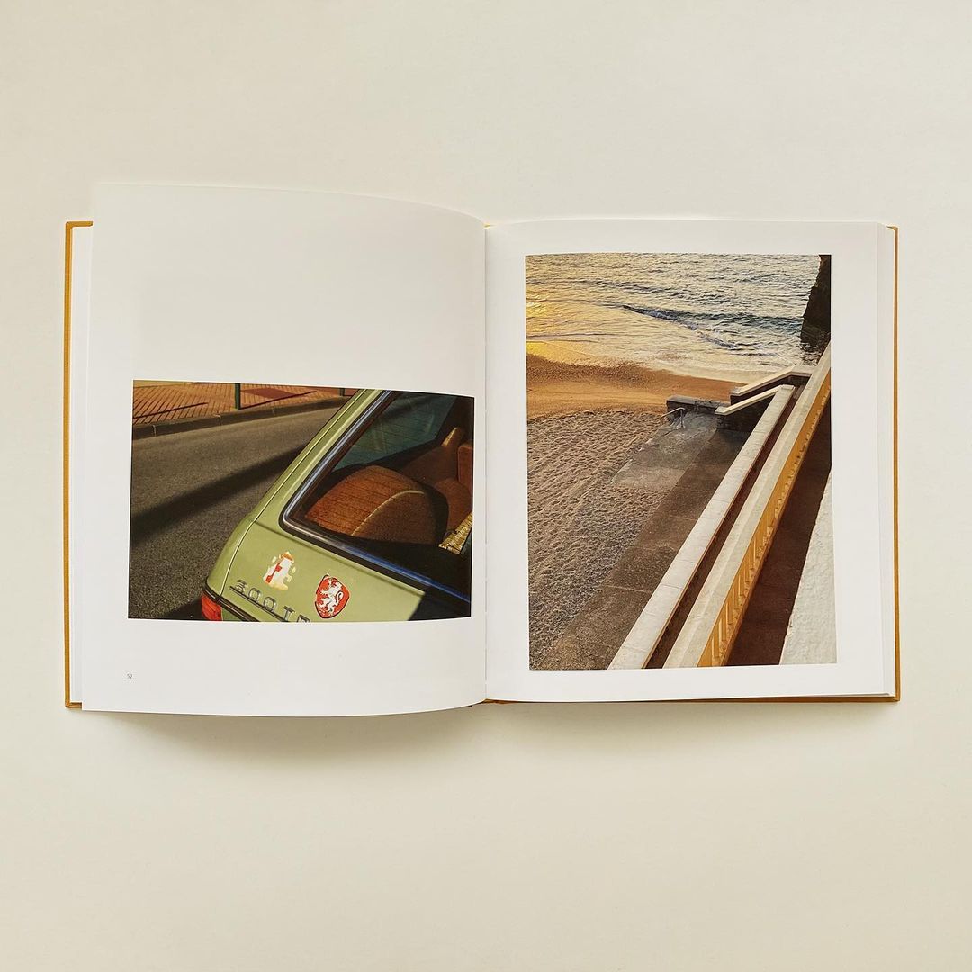 An open book displays photographs of a vintage car and a beach at sunset, blending automotive and scenic elements in a unique layout.